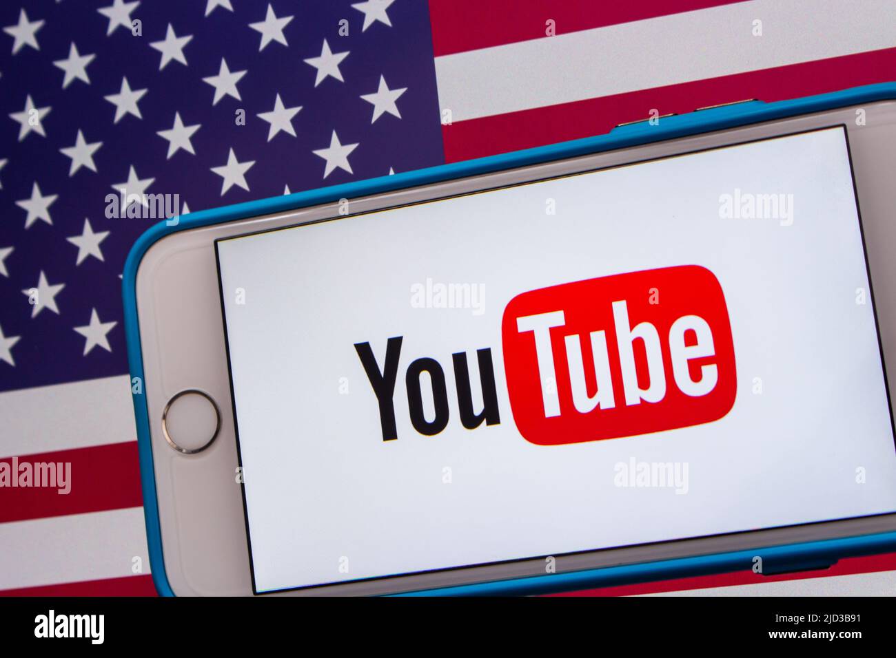 Kumamoto, GIAPPONE - Feb 22 2022 : l'immagine concettuale del logo di YouTube su un iPhone su sfondo di una bandiera americana. Foto Stock