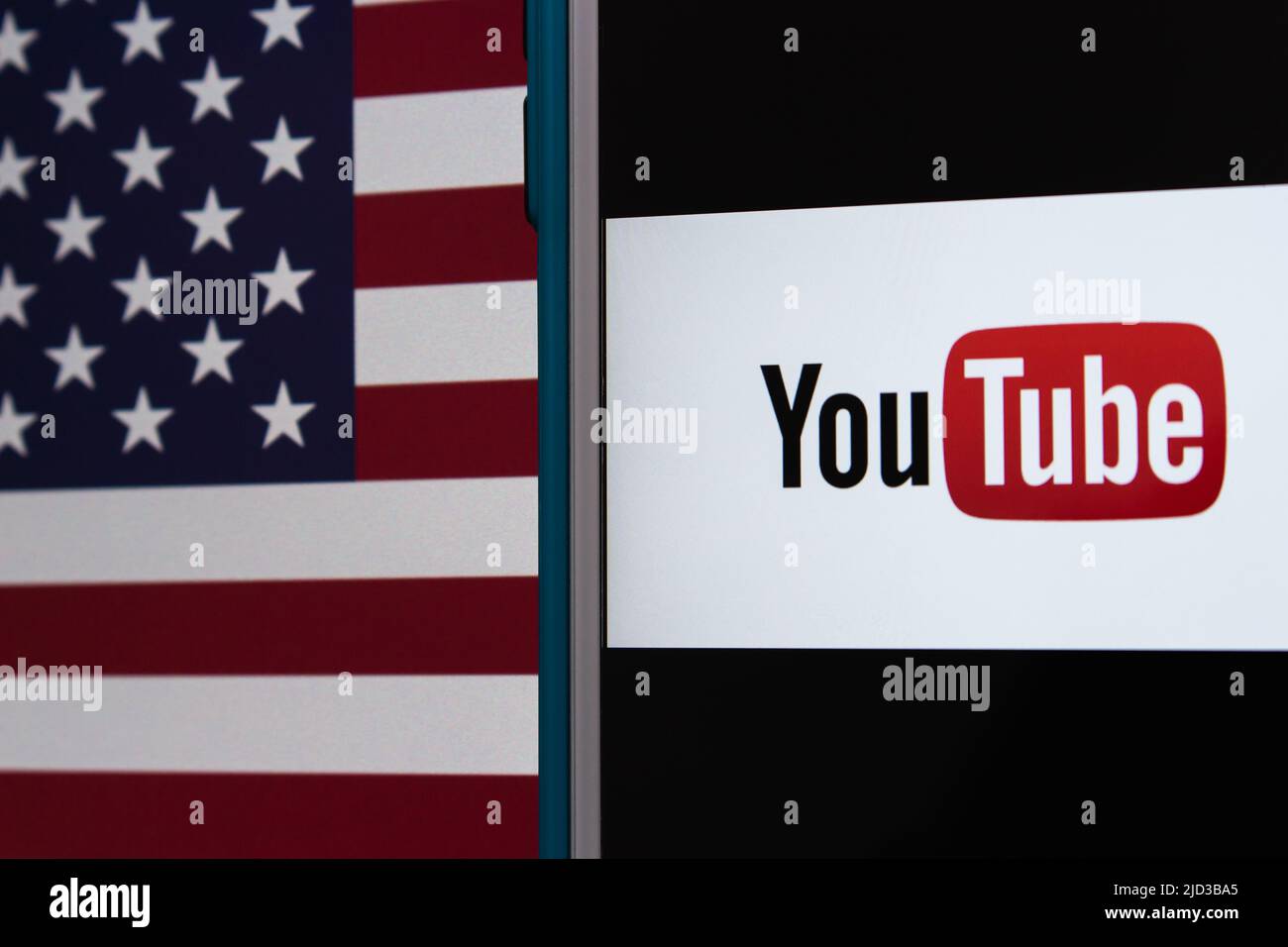 Kumamoto, GIAPPONE - Feb 22 2022 : l'immagine concettuale del logo di YouTube su un iPhone su sfondo di una bandiera americana. Foto Stock