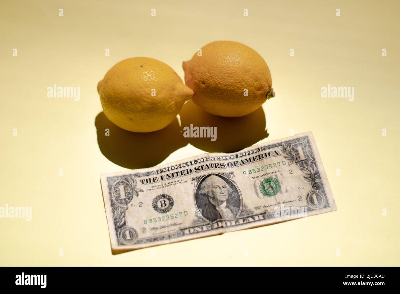 Due limoni e una banconota da un dollaro Foto Stock
