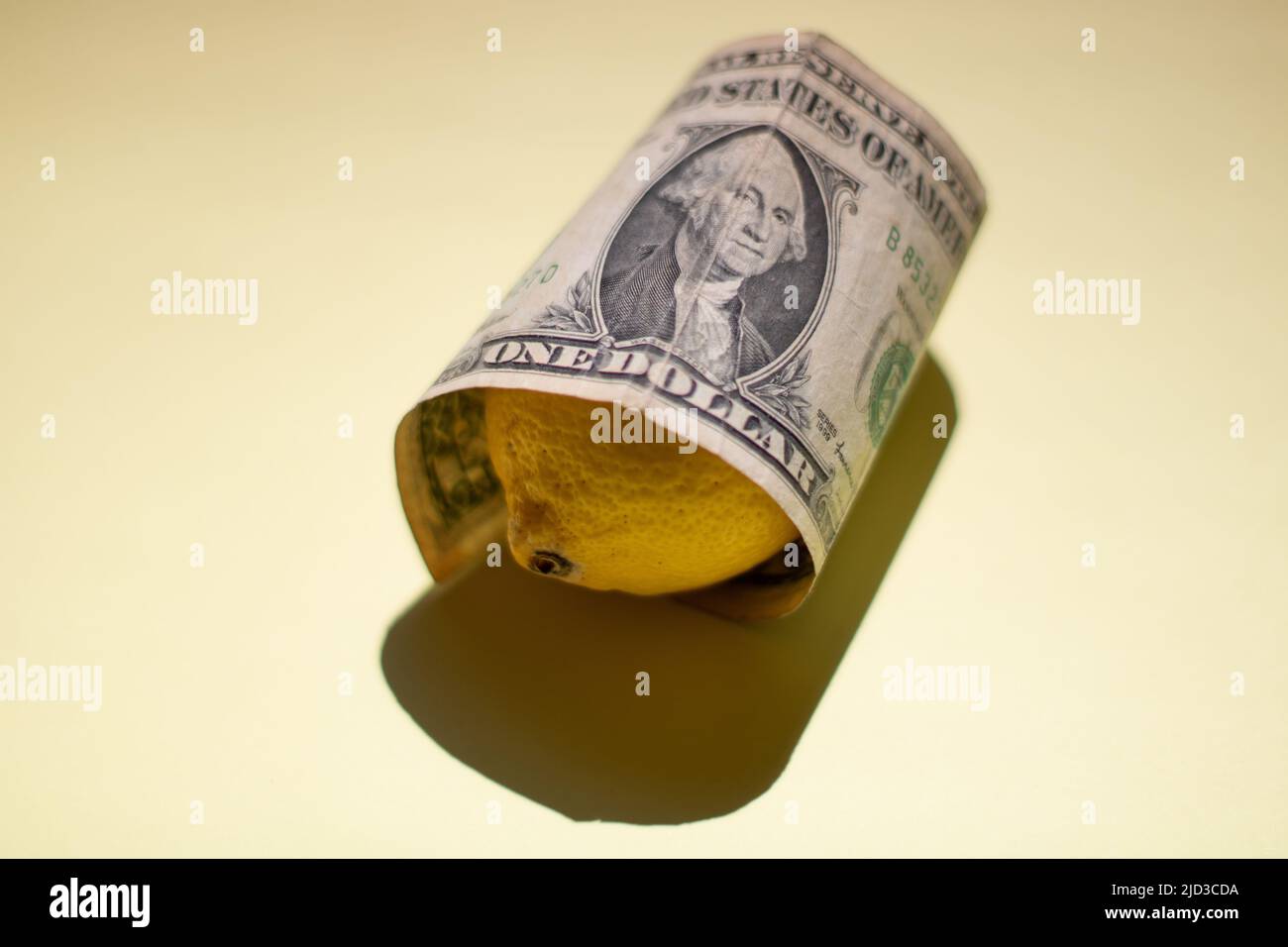 Una banconota da un dollaro e' avvolta su Lemon Foto Stock