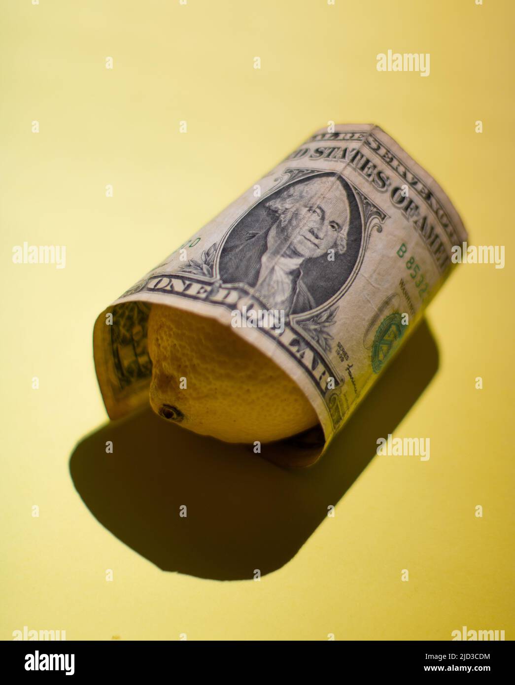 Una banconota da un dollaro e' avvolta su Lemon Foto Stock