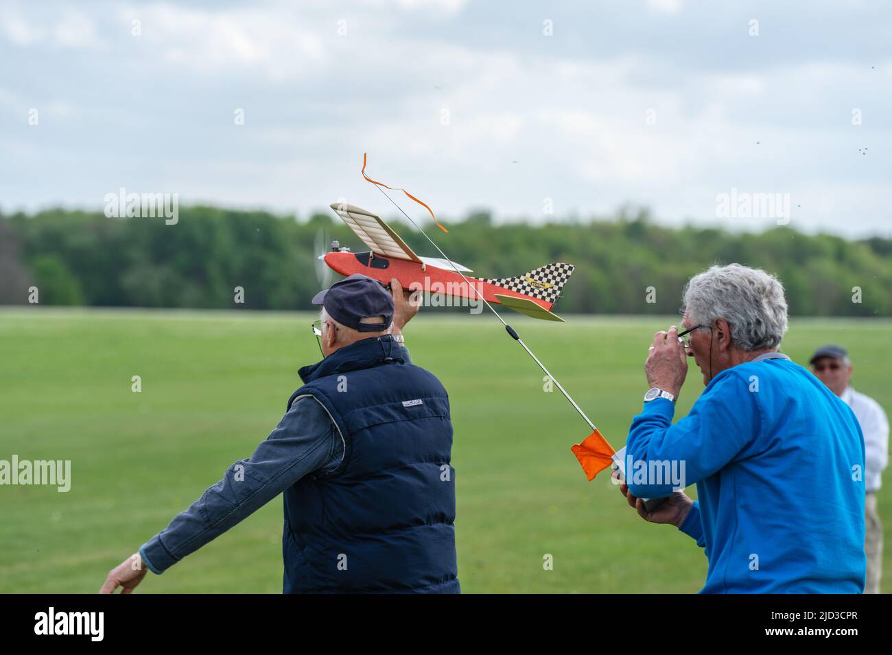 L'uomo lancia l'aereo modello sul campo d'erba. Shuttleworth, Inghilterra, 8 maggio 2022 Foto Stock