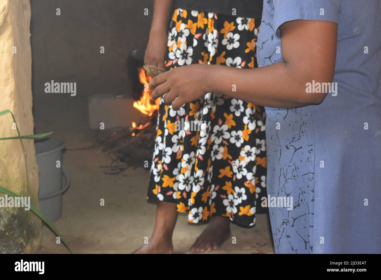 Persone che cucinano su una stufa a legna. La stufa è fatta di 3 pietre grandi e legno asciutto. In Sri Lanka vi è una grande carenza di gas e petrolio di cherosene, quindi la gente deve usare metodi alternativi per cucinare. Questo tipo di stufa è comunemente usato nei villaggi rurali, ma a causa della crisi si è diffuso ad aree urbane. Colombo, Sri Lanka. Foto Stock