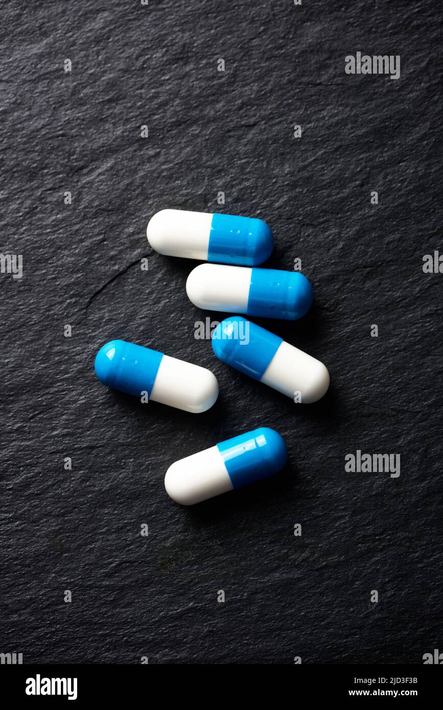 Supplementi sportivi (creatina capsule) su sfondo di pietra scura. Vista dall'alto. Primo piano. Spazio di copia. Foto Stock