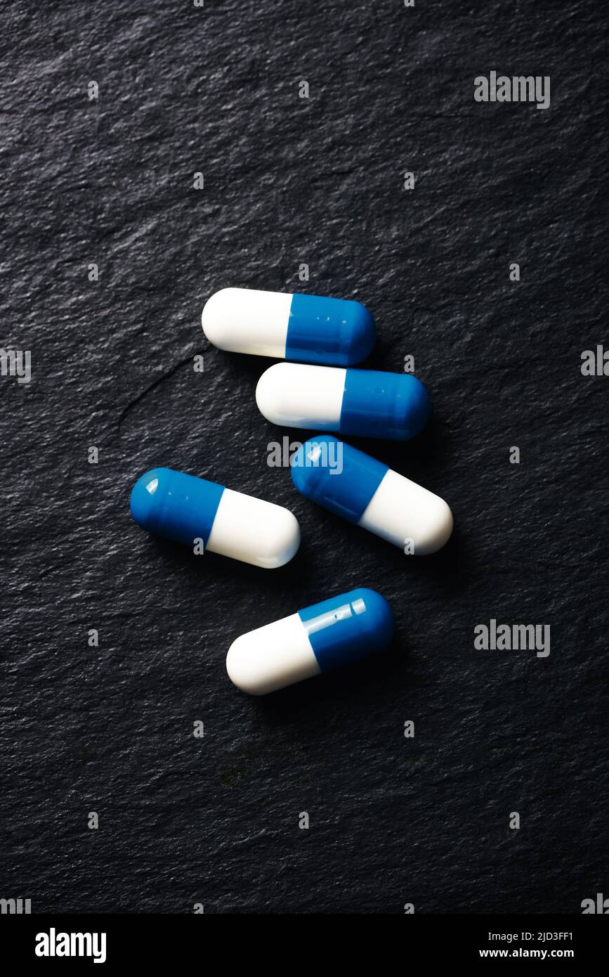 Supplementi sportivi (creatina capsule) su sfondo di pietra scura. Vista dall'alto. Primo piano. Spazio di copia. Foto Stock