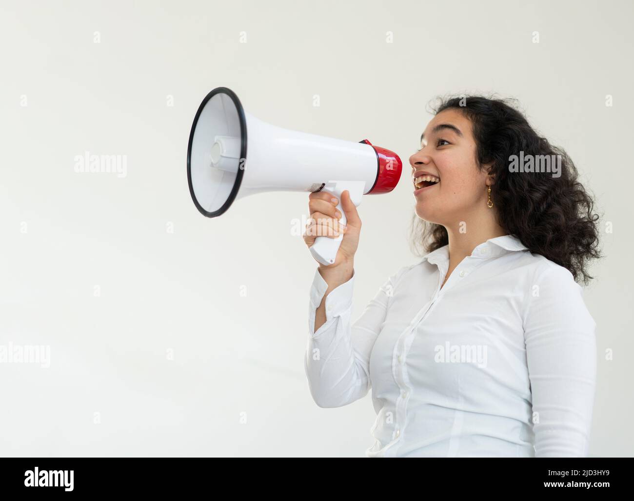 Bella donna d'affari con capelli ricci che tiene un megafono. Foto di alta qualità Foto Stock