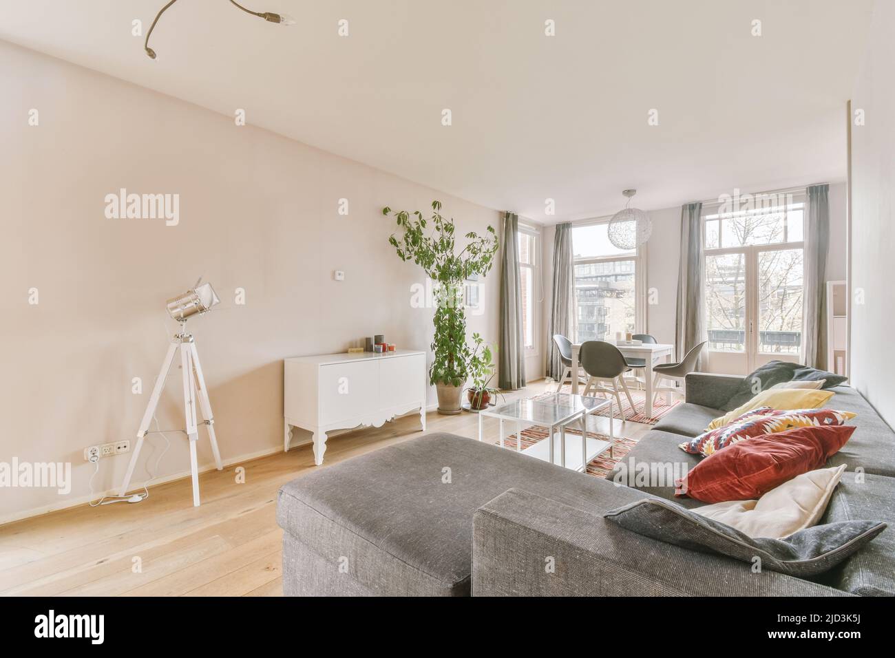 Interno di soggiorno con comodo divano e finestre in appartamento contemporaneo Foto Stock