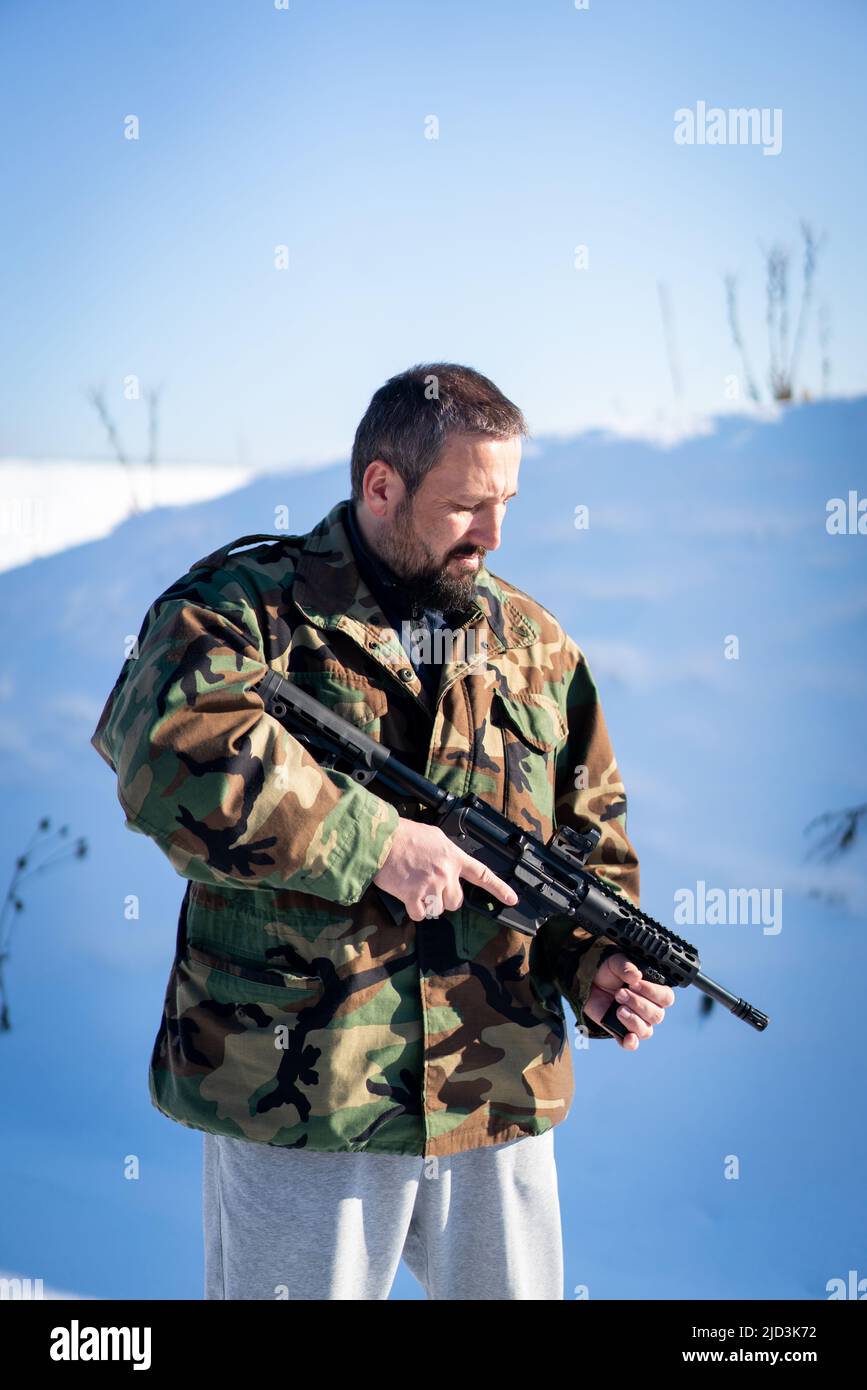 Soldato maschio in uniforme militare sulla neve d'inverno. Foto di alta qualità Foto Stock