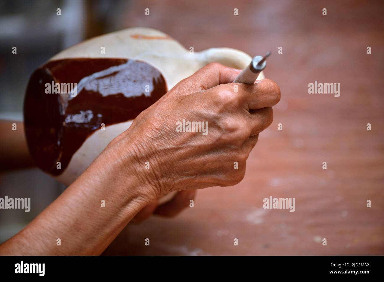 Vista ravvicinata di una donna anziana che forma un blocco di argilla e che fa una pentola di ceramica Foto Stock