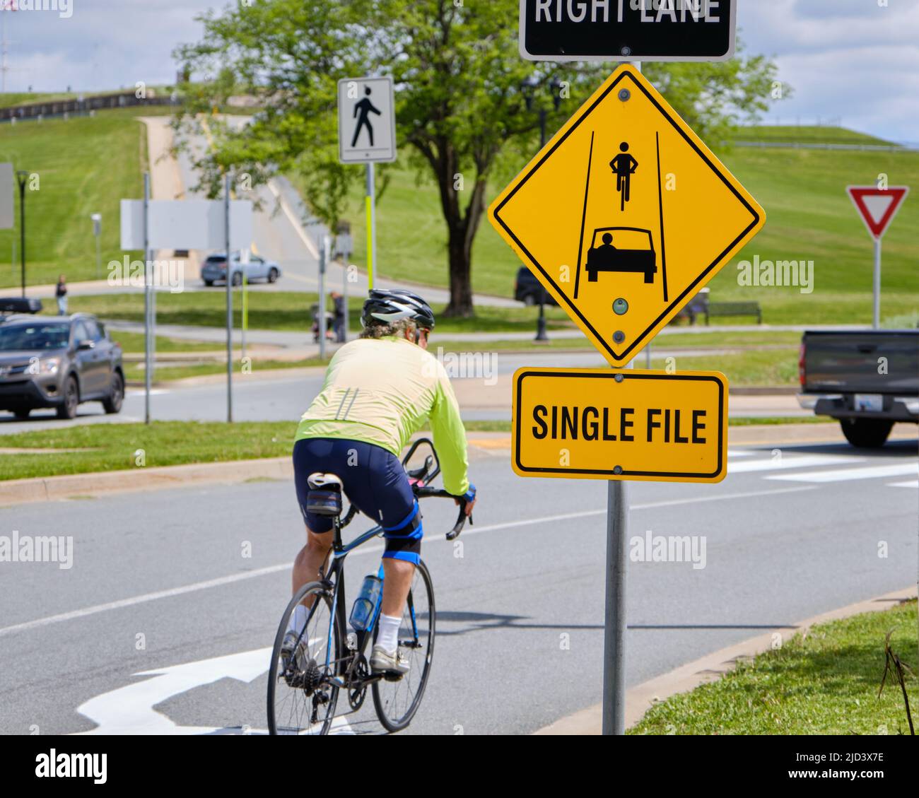 Segnaletica stradale che dice ai ciclisti e ai conducenti di auto che la maggior parte formano un unico file come la rotonda di avvicinamento Foto Stock