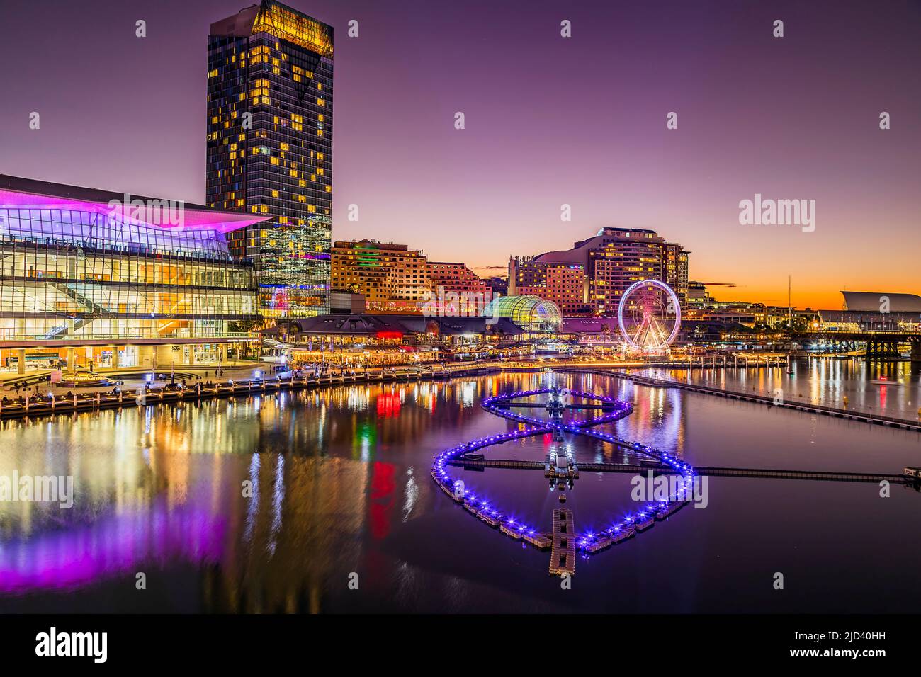 Fontana galleggiante sulle acque del Porto di Darling a Sydney al Vivid Sydney ligth show - tramonto paesaggio urbano. Foto Stock