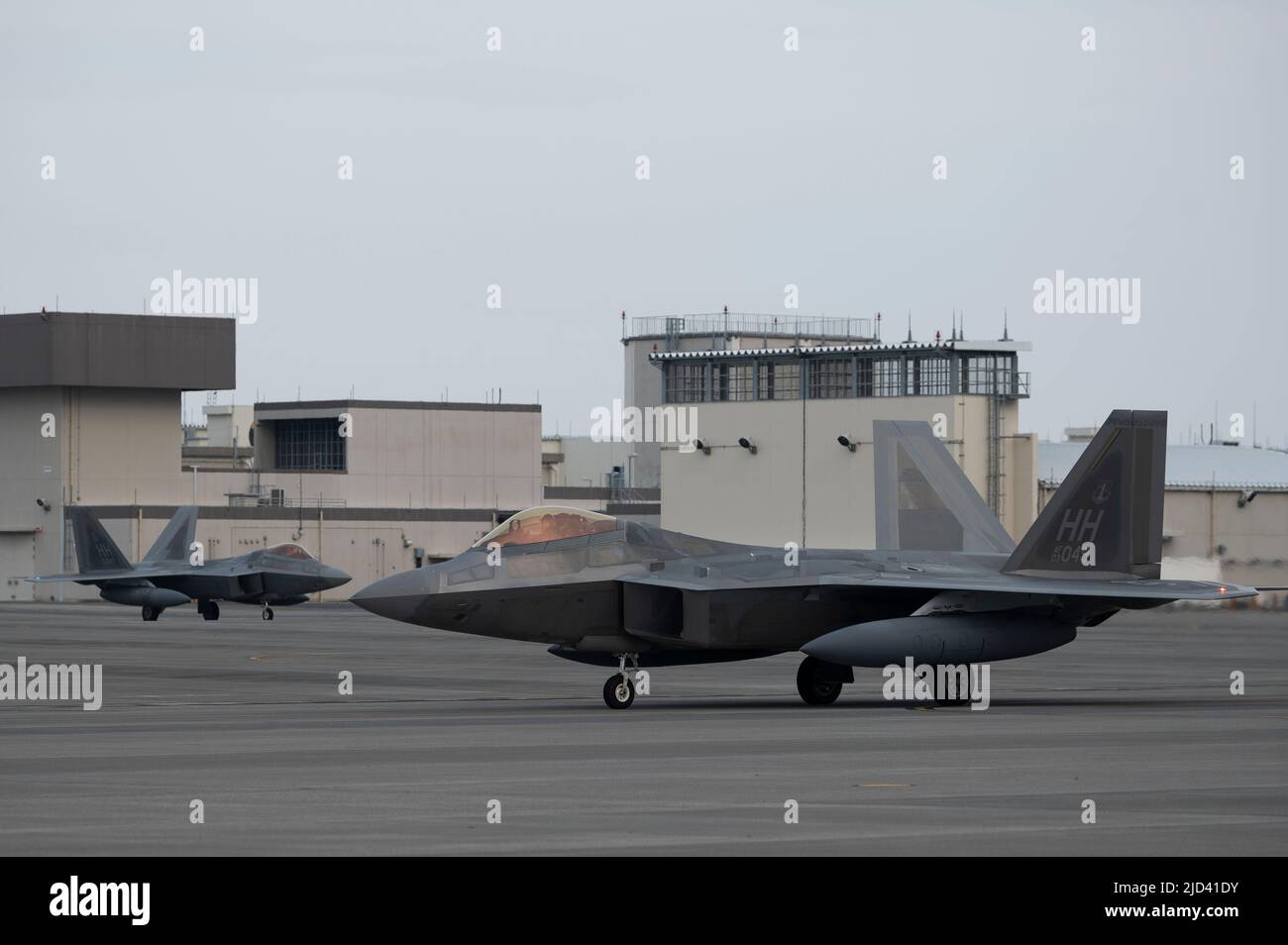 Due aerei da combattimento US Air Force F-22 Raptor assegnati al taxi 199th Expeditionary Fighter Squadron sulla pista all'arrivo a un agile evento di addestramento al lavoro di combattimento alla Marine Corps Air Station Iwakuni, Giappone, 15 giugno 2022. Durante l'evento di formazione ACE, l'EFS 199/19th viene assegnato all'ala di spedizione aerea 354th e opera con il 356th Squadrone di caccia di spedizione per perfezionare le tattiche, le tecniche e le procedure di integrazione di quinta generazione. (STATI UNITI Air Force foto di staff Sgt. Zade Vadnais) Foto Stock