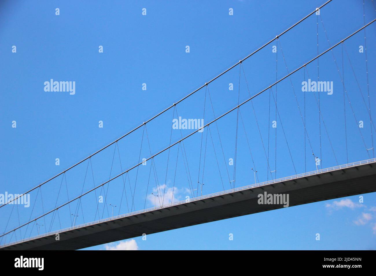 Vista ravvicinata di un ponte visto dal basso con un cielo limpido con una piccola nuvola sullo sfondo Foto Stock
