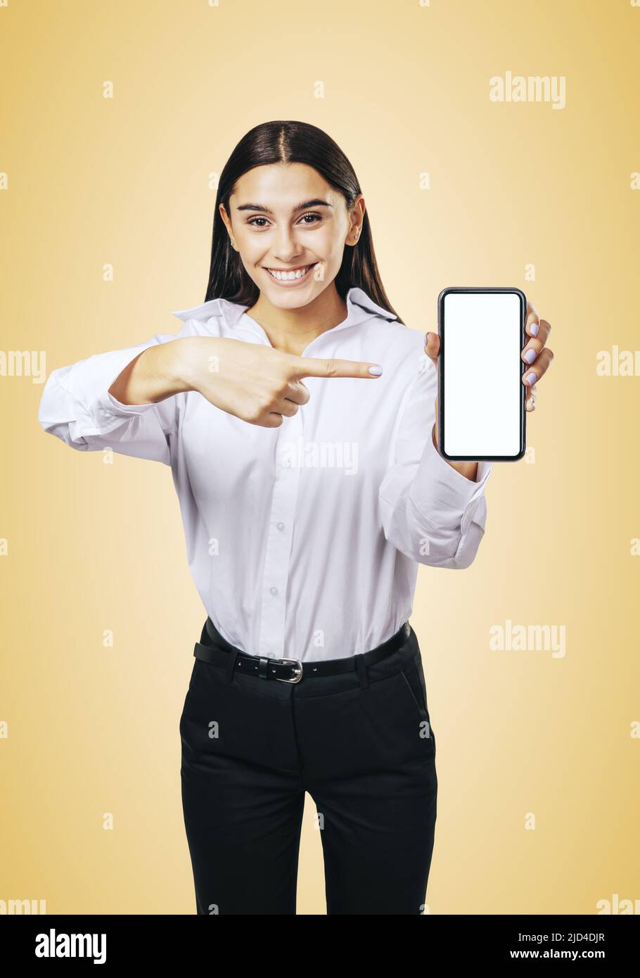 Concetto di applicazione mobile con uomo d'affari sorridente in camicia bianca che mostra il cellulare moderno con schermo bianco vuoto su astratto luce arancione backgro Foto Stock