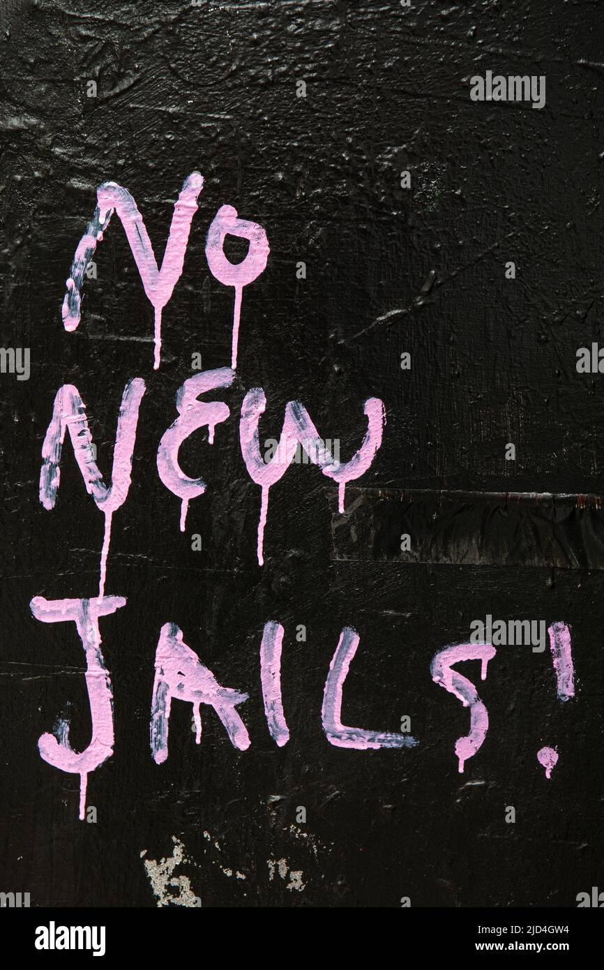 Nessuna nuova carceri! Testo rosa sul muro nel quartiere di Chinatown di Manhattan, New York City, Stati Uniti d'America. Foto Stock