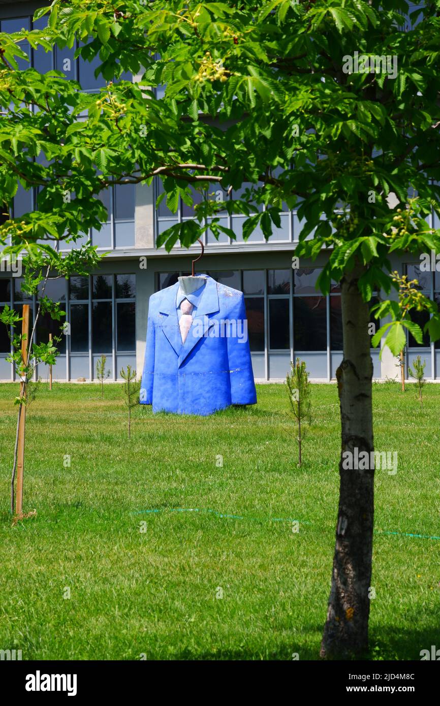 Statua di abito top con giacca blu, camicia e cravatta al giardino di progettazione facoltà in una giornata di sole Foto Stock