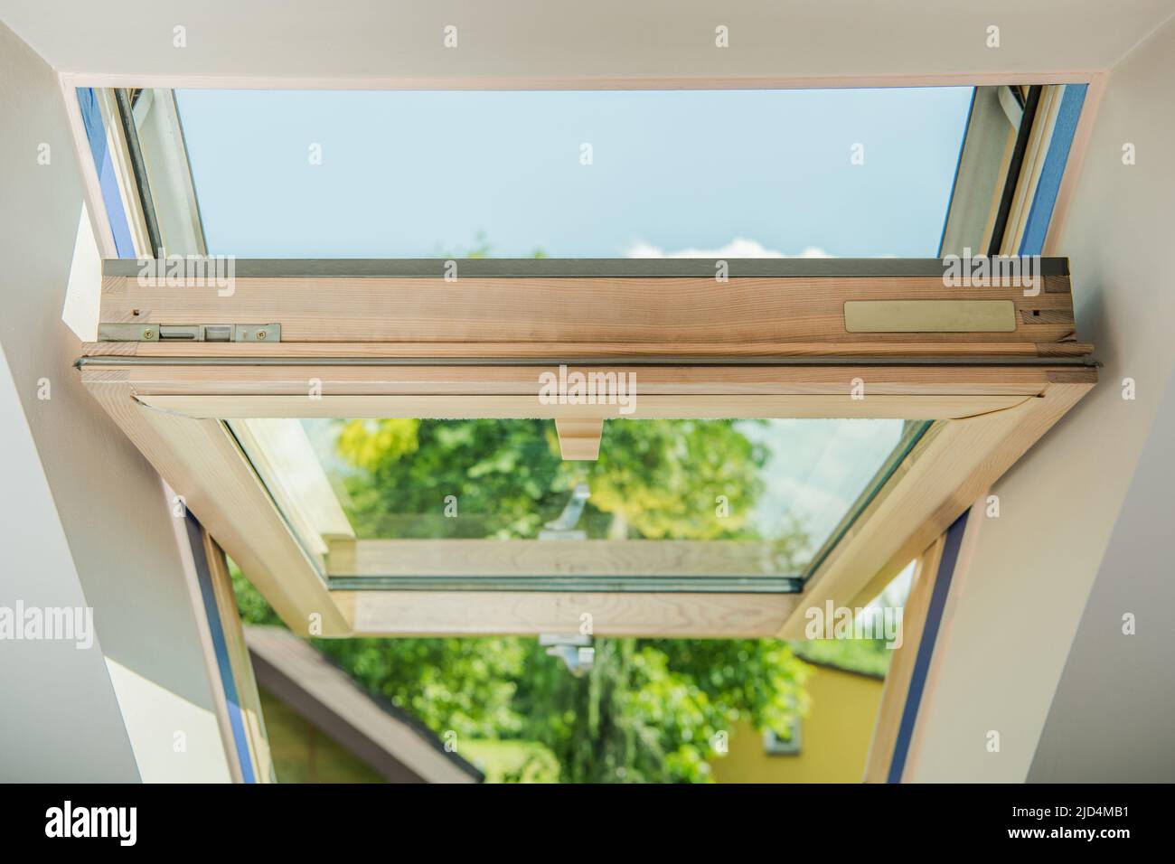 Primo piano di un finestrino del tetto in legno aperto. Nuova installazione nell'edificio residenziale. Foto Stock