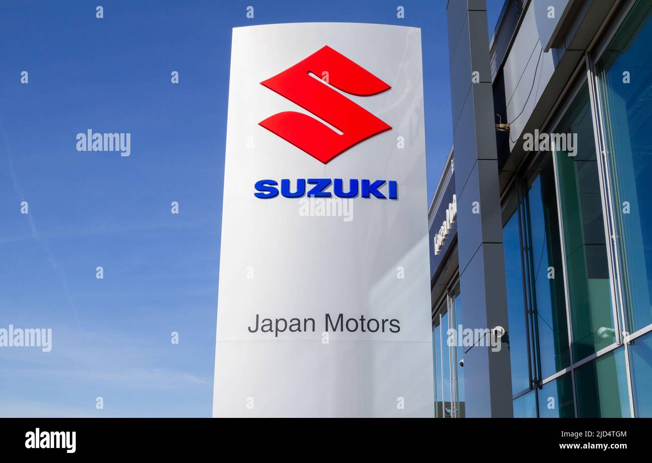 Edificio della concessionaria Suzuki Japan Motors. Salone auto giapponese del produttore di auto con segno del logo corporativo. Cartello in pilone, logo del marchio aziendale. Foto Stock