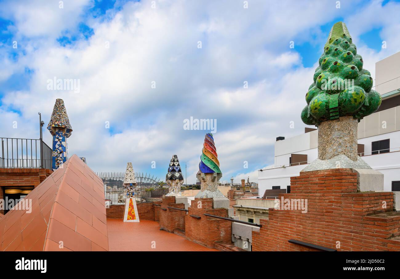 Barcellona, Spagna. I colorati camini mosaici realizzati con piastrelle in ceramica spezzate sul tetto del Palau Guell progettato dall'architetto catalano Antoni Gaudi Foto Stock
