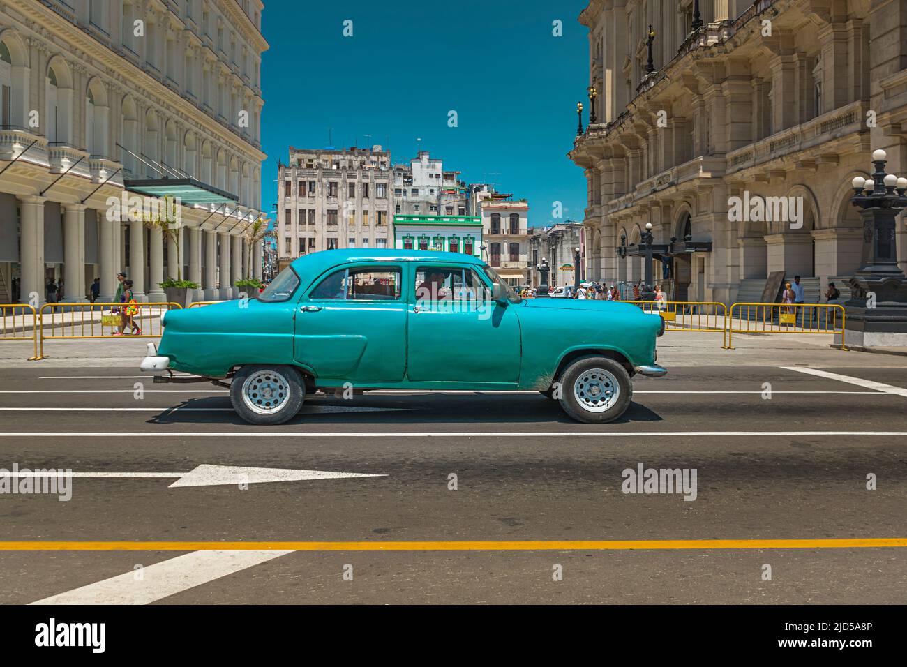 Auto verde d'epoca passando Parque Central a l'Avana, Cuba Foto Stock