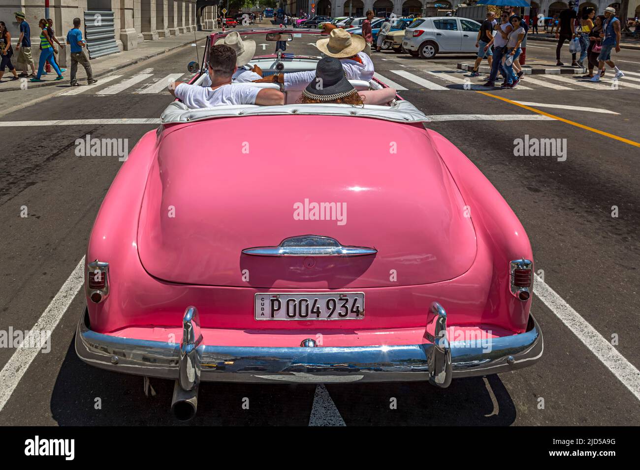 Una bella auto rosa d'epoca da dietro in attesa ad un semaforo al Parque Central a l'Avana, Cuba Foto Stock