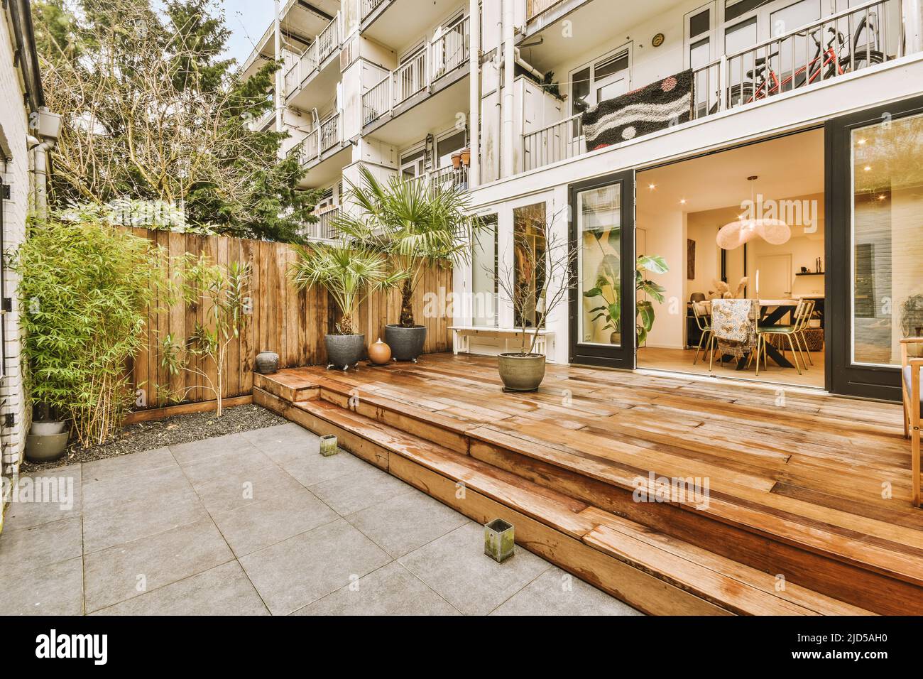 Cortile Ponte della moderna casa europea. Foto di alta qualità. Ponte in legno con cielo nuvoloso e alberi verdi Foto Stock