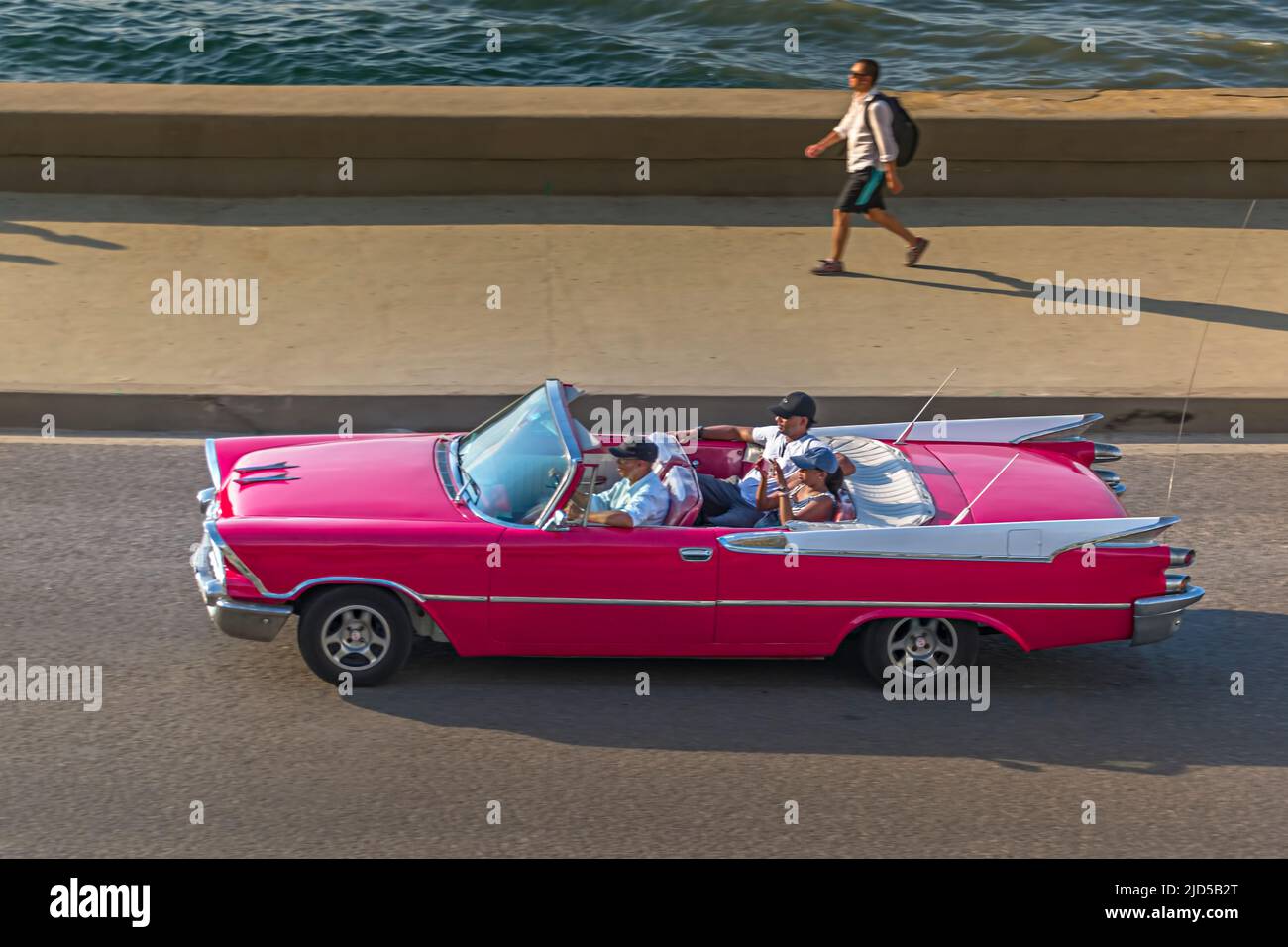 Una bella auto d'epoca rosa sul Malecon a l'Avana, Cuba Foto Stock