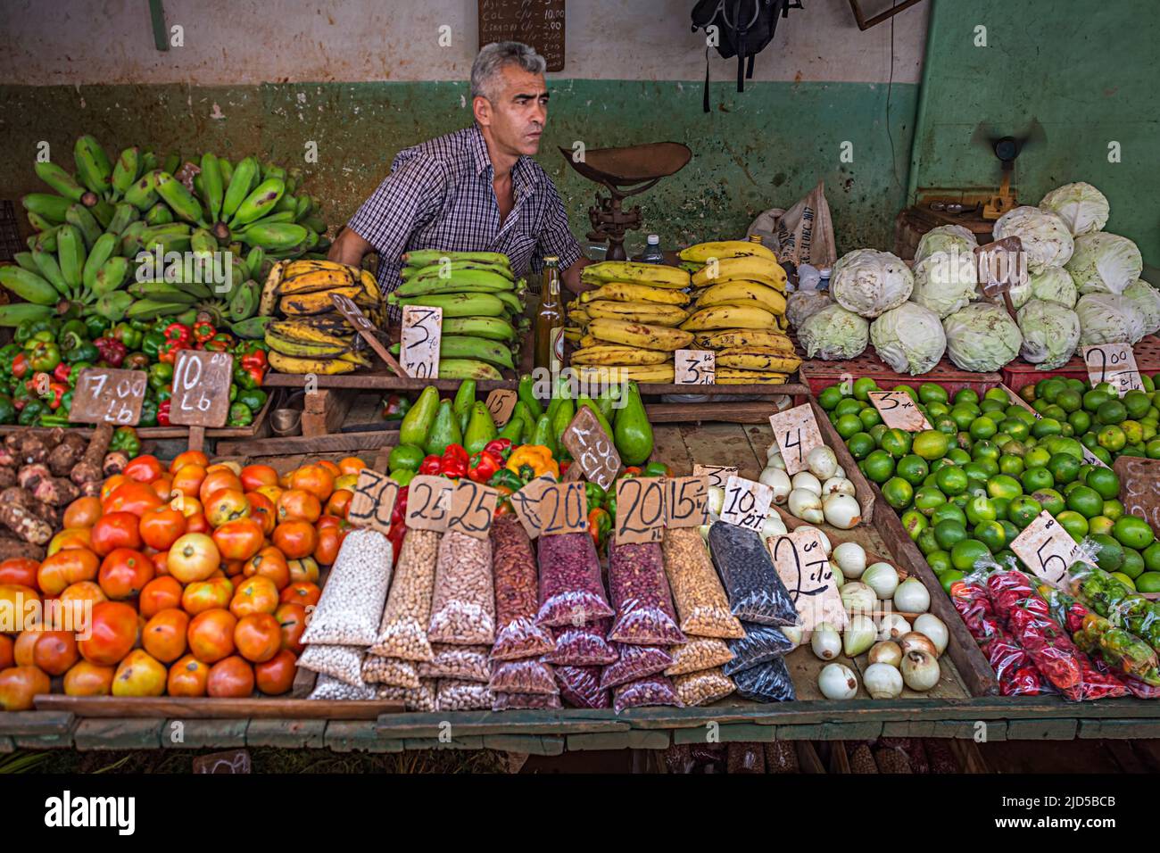 Venditore di prodotti alimentari che vendono frutta e verdura su un mercato a Old Havana, Cuba Foto Stock