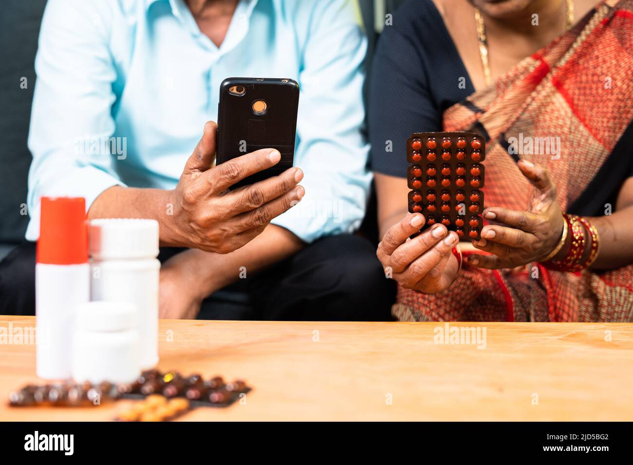 primo piano della vecchia coppia anziana che ordina medicinali sul telefono cellulare da casa - concetto di assistenza sanitaria, tecnologia e e-commerce Foto Stock