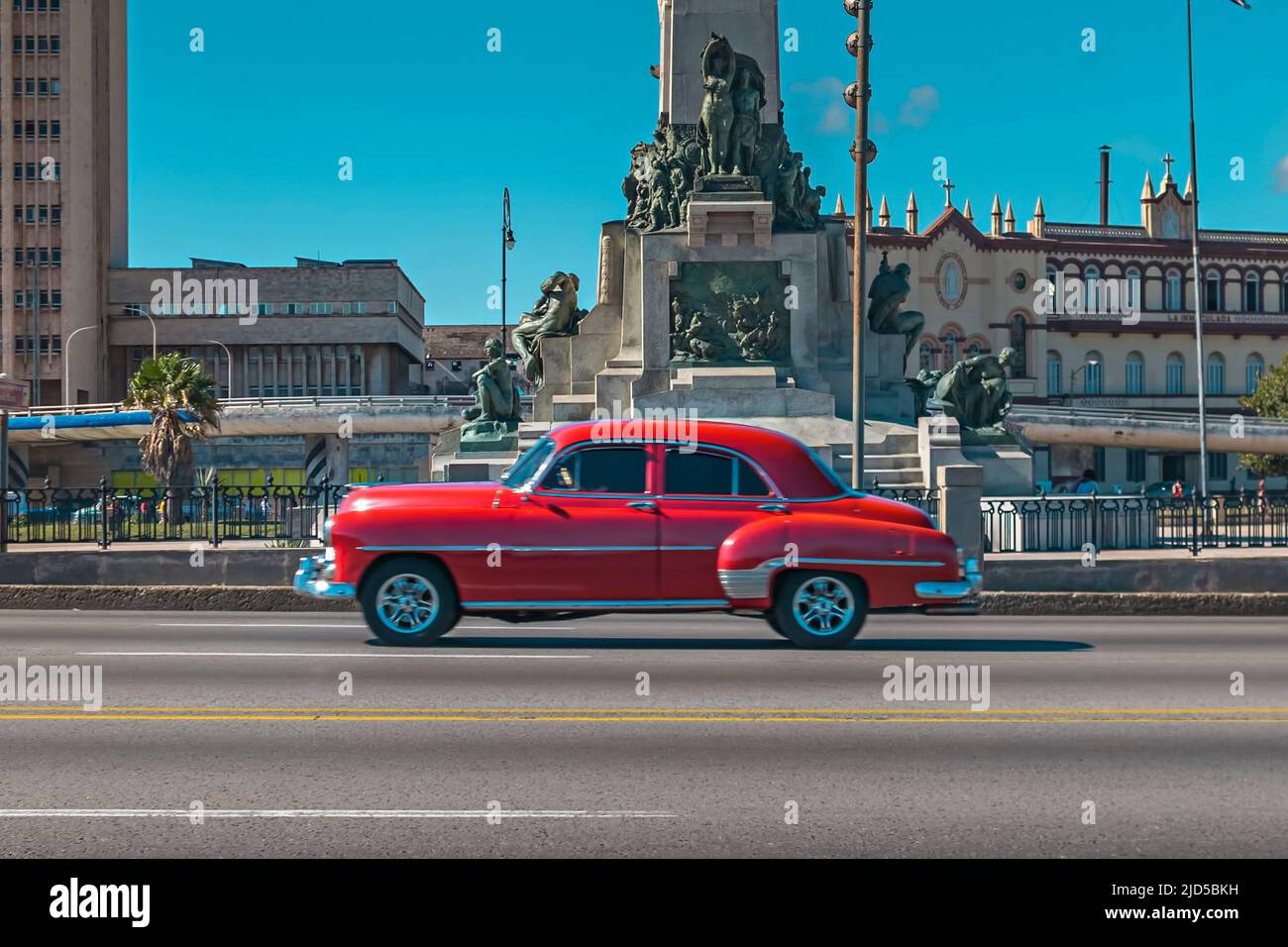 Una bella auto d'epoca rossa guida sul famoso Malecon a l'Avana, Cuba Foto Stock