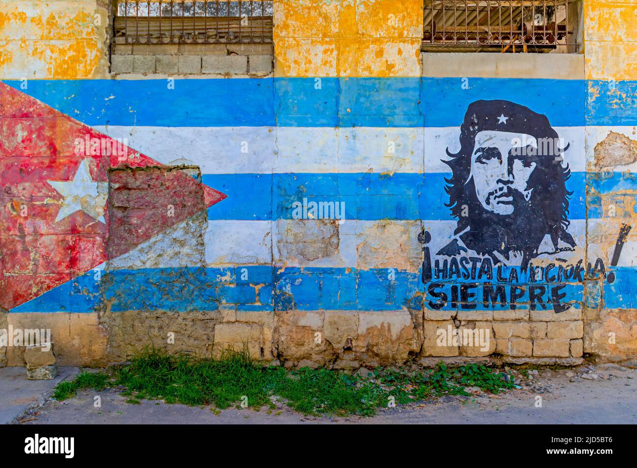 Muro murale della bandiera cubana e che Guevara con testo che dice 'Hasta la victoria siempre' Foto Stock