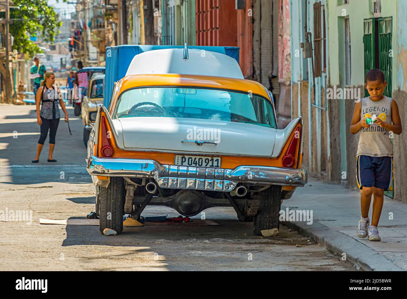 Auto d'epoca gialla e bianca con cofano aperto parcheggiato su una strada a Old Havana, Cuba Foto Stock