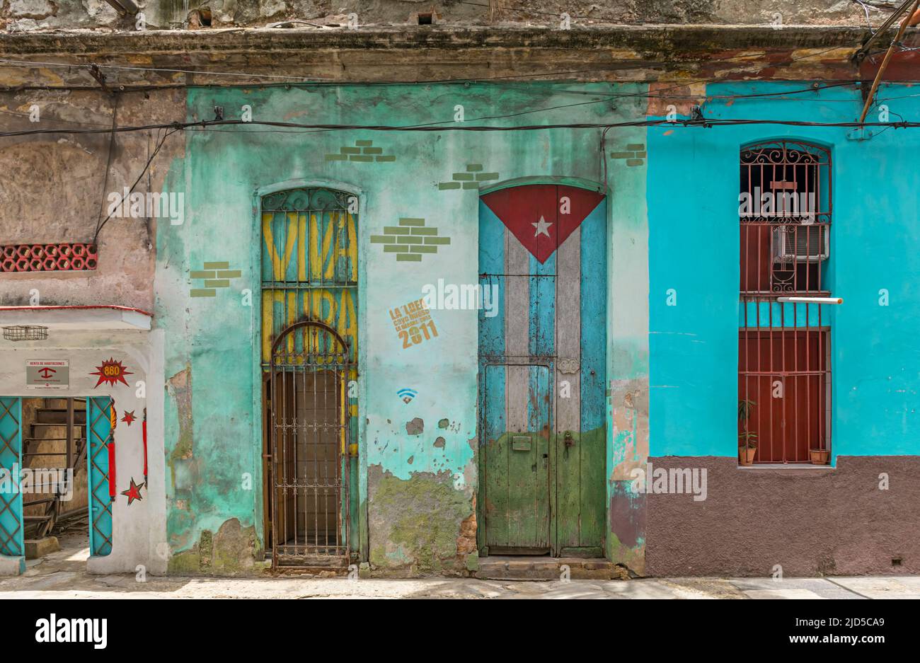 Facciata colorata casa con bandiera cubana dipinta a Old Havana, Cuba Foto Stock