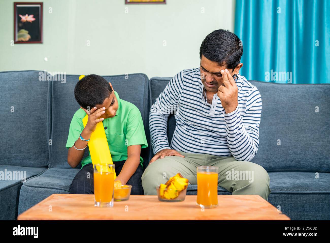 Padre e figlio si sono arrabbiato mentre guardavano la partita di cricket dal vivo a casa a causa della perdita della partita o del wicket - concetto di intrattenimento, appassionati di sport e infelici Foto Stock