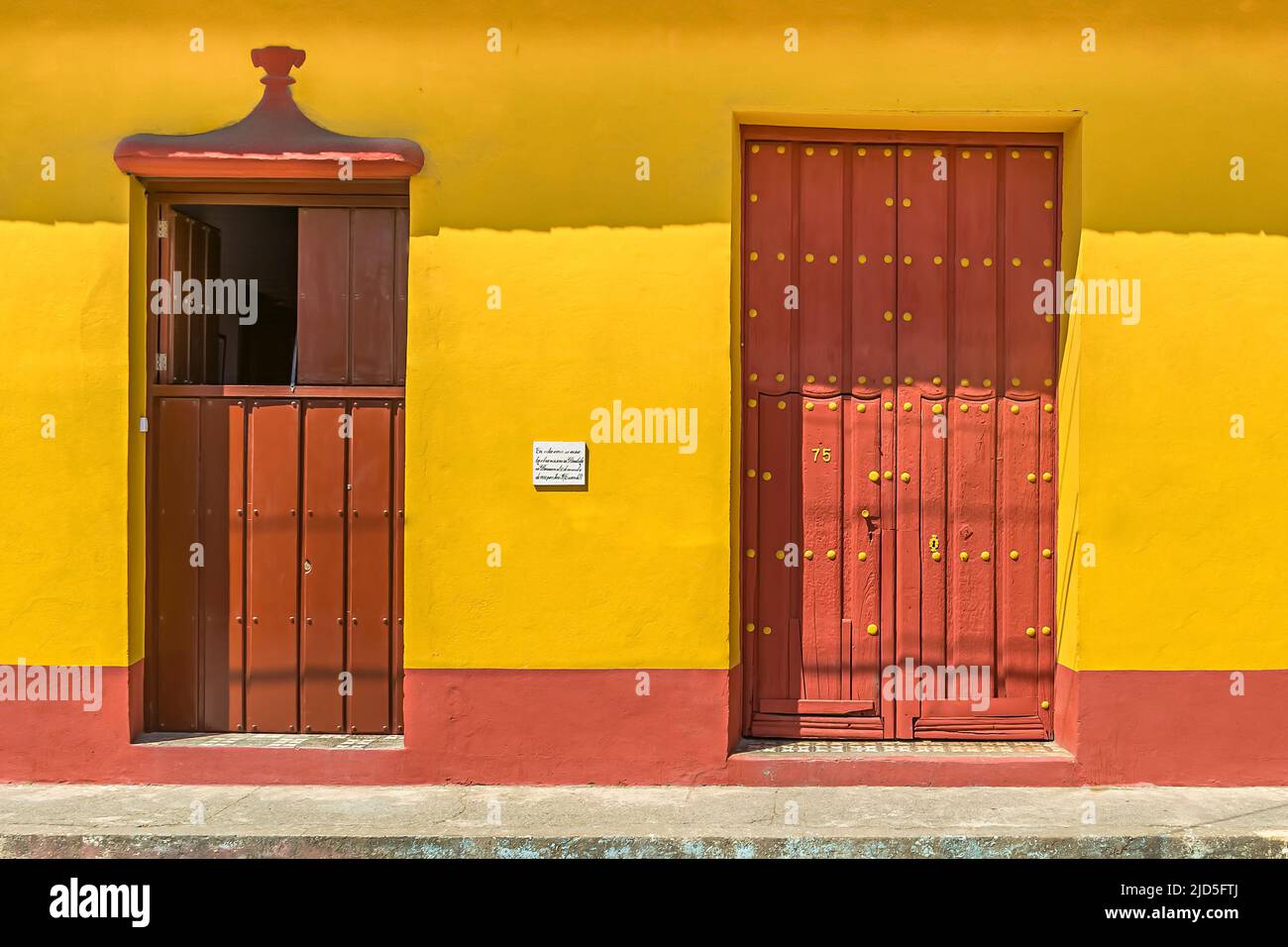 Bella casa gialla con porte rosso scuro per le strade di Baracoa, Cuba Foto Stock
