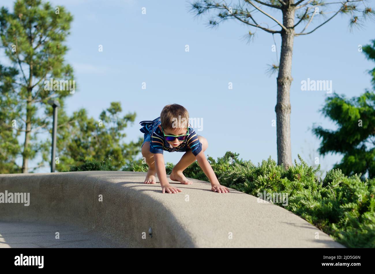 concetto di vacanza. bambino che guida scooter, a piedi nella città vecchia, strada. Risate in una giornata estiva di sole. Divertirsi Foto Stock