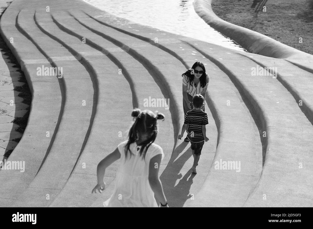 Felice stile di vita familiare e concetto di vacanza. Madre, ragazzino, ragazza seduta, camminando nella città vecchia, in strada, ridendo in una giornata estiva di sole. Foto Stock