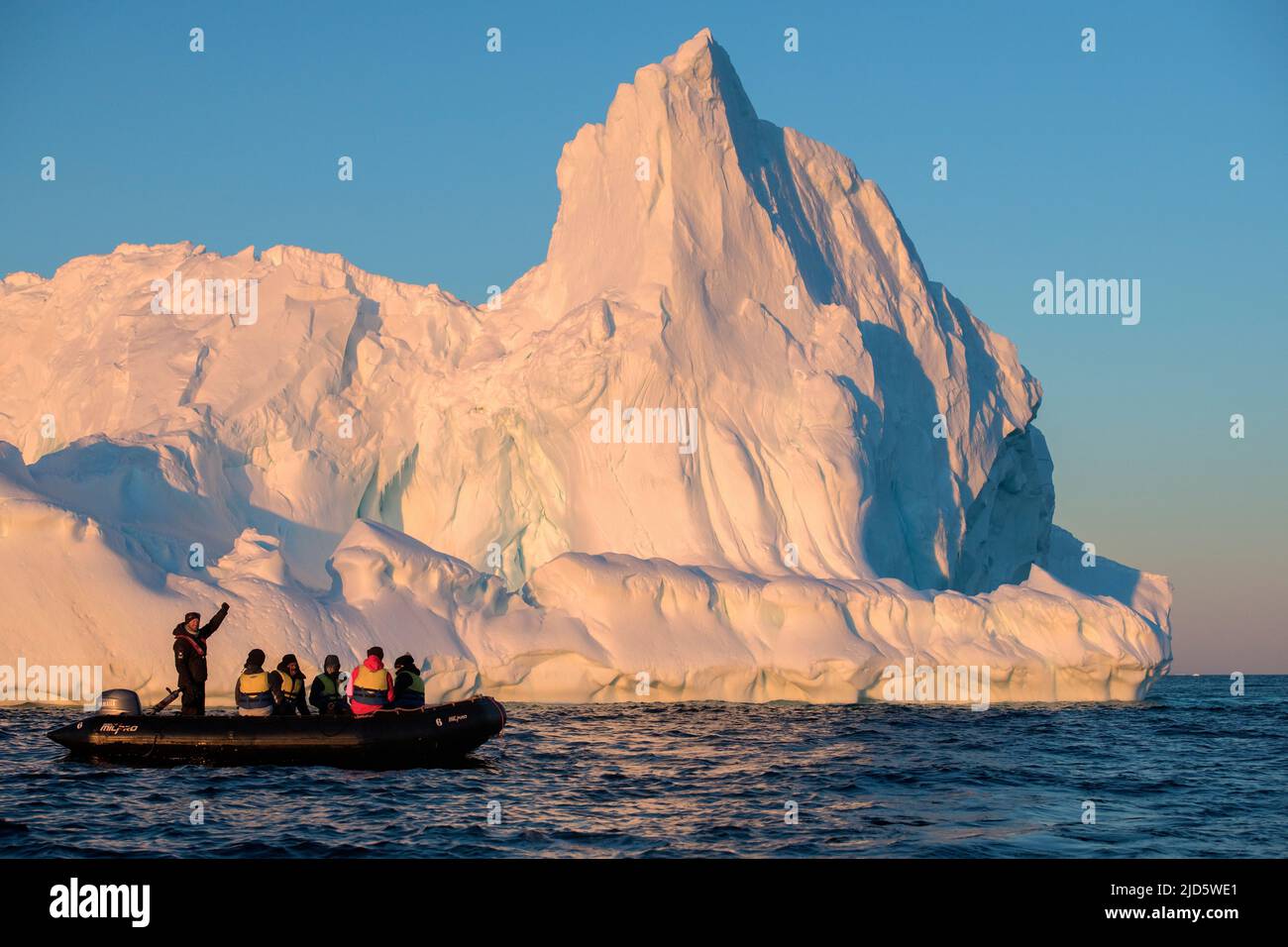 Serata con ecoturisti e iceberg a Hydruca Rocks, arcipelago Palmer, Antartide. Foto Stock