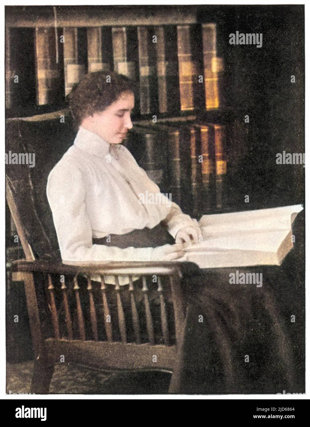 Helen Adams Keller (1880-1968), autore e docente americano, cieco, sordo e muto dall'età di 19 mesi; seduto su una sedia, leggendo un libro versione Colorizzata di : 10070586 Foto Stock