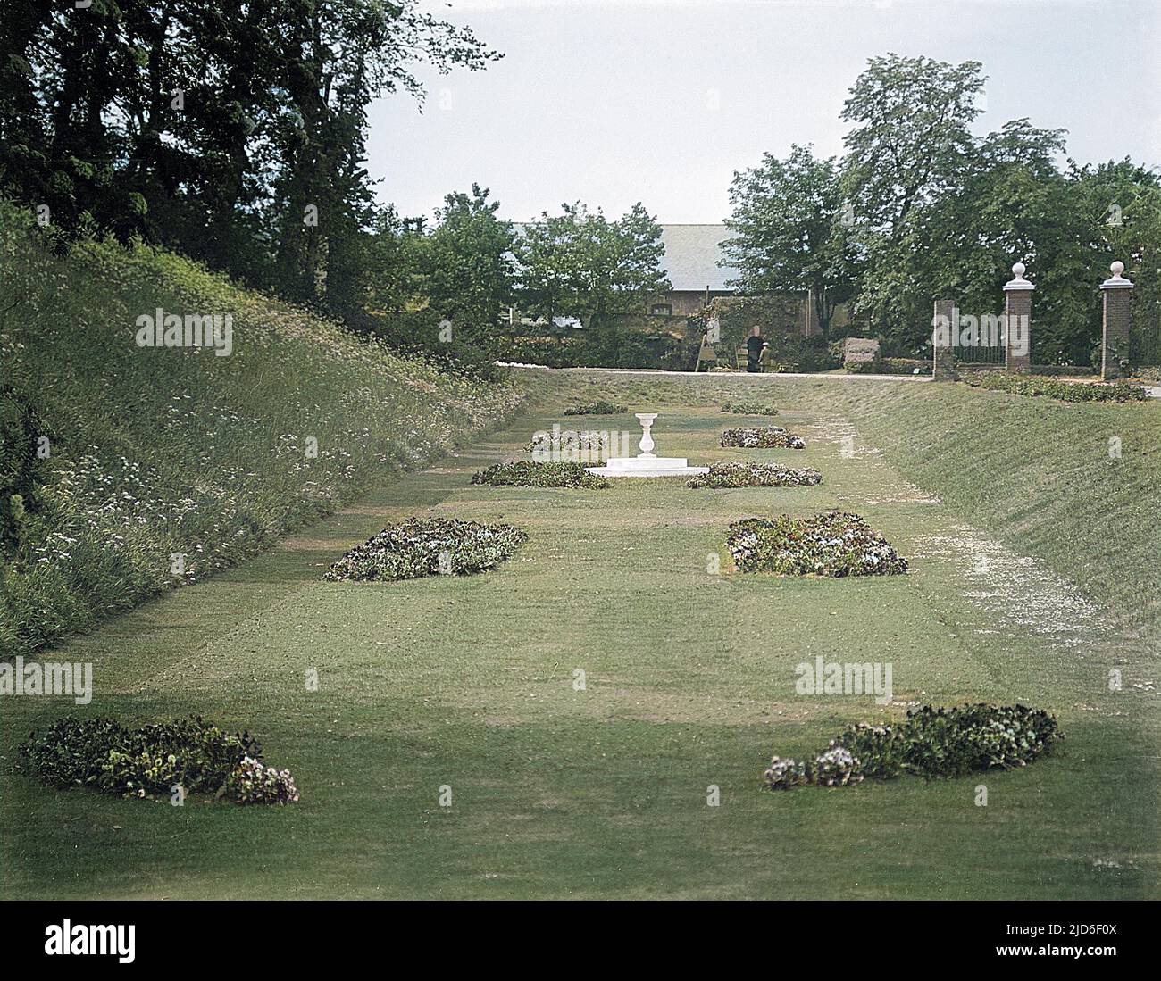 Un prato affondato ben tenuto e aiuole di fiori nei giardini pubblici a Colchester, Essex, Inghilterra. Versione colorata di : 10163438 Data: Inizio 1930s Foto Stock