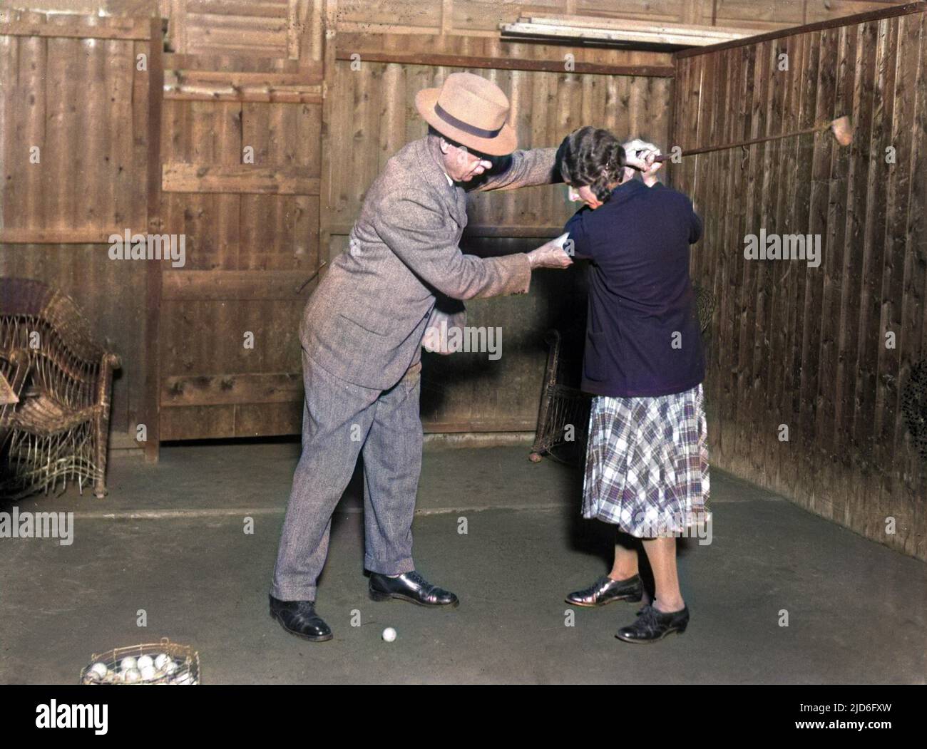 Una donna golfer che è insegnata come colpire correttamente la sfera al randello interno di golf di Milbury Court 'tutto il tempo '. Versione colorata di : 10168946 Data: Inizio 1930s Foto Stock