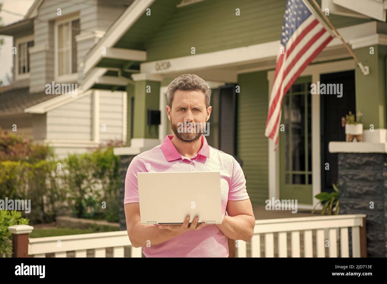 bordati uomo broker vendere o affittare casa con bandiera americana su pc online, a casa Foto Stock
