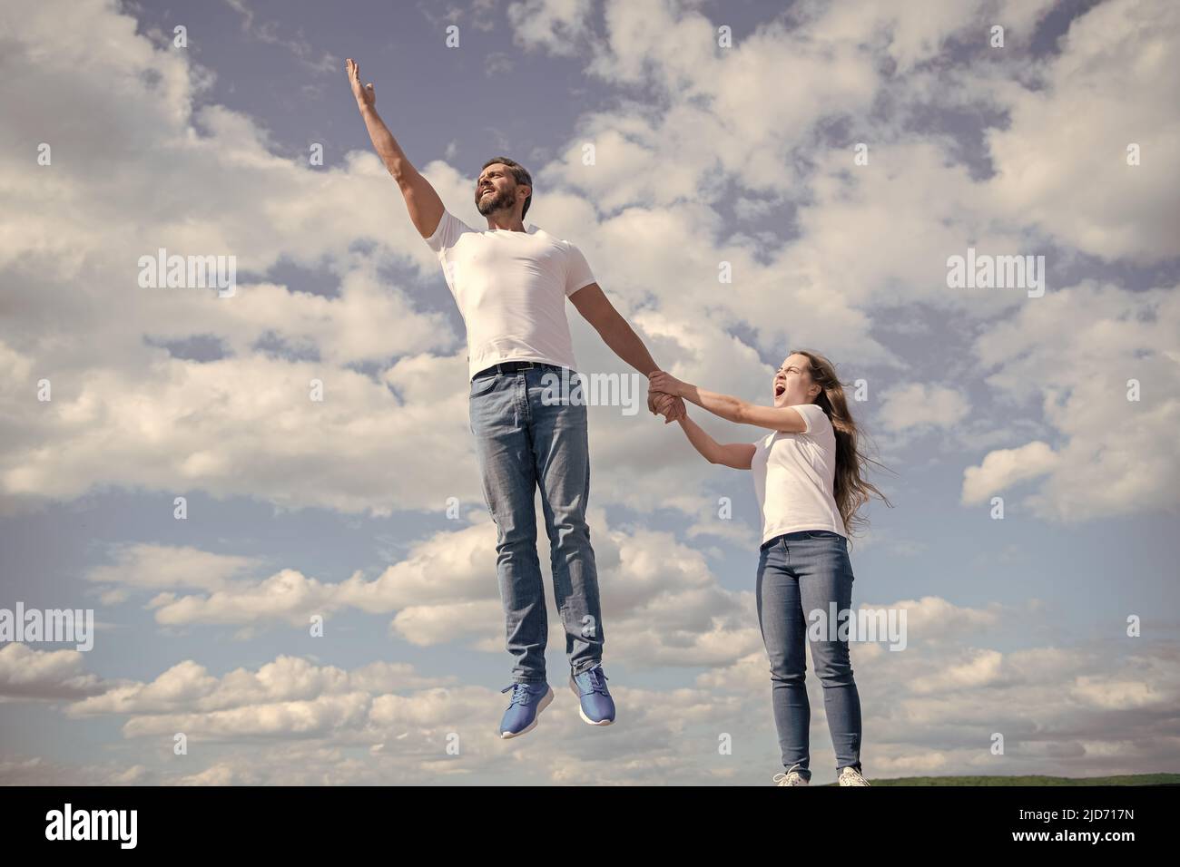 la figlia tiene suo papà che salta in cielo Foto Stock