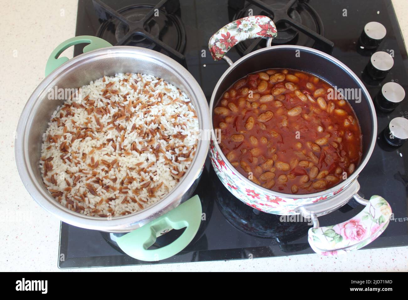 Pinto o fagioli di rene e pilaf di riso in pentola sul fornello. Vista ravvicinata e dall'alto su fagioli pinto cotti e pilaf di riso. Foto Stock