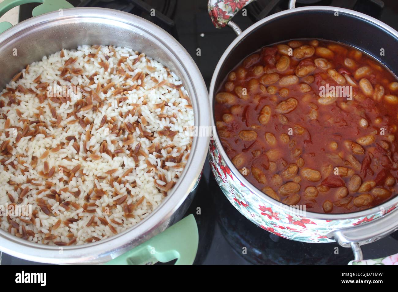 Pinto o fagioli di rene e pilaf di riso in pentola sul fornello. Vista ravvicinata e dall'alto su fagioli pinto cotti e pilaf di riso. Foto Stock