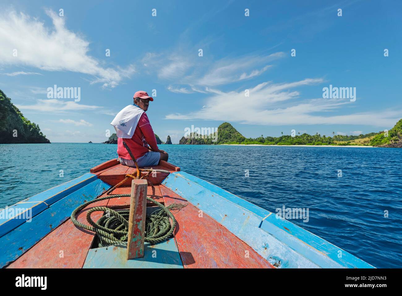 Capitano di viaggio in barca al largo dell'isola di Siau con la bella sabbia bianca Masare Island oltre. Masare, Siau, Arcipelago di Sangihe, Sulawesi settentrionale, Indonesia Foto Stock