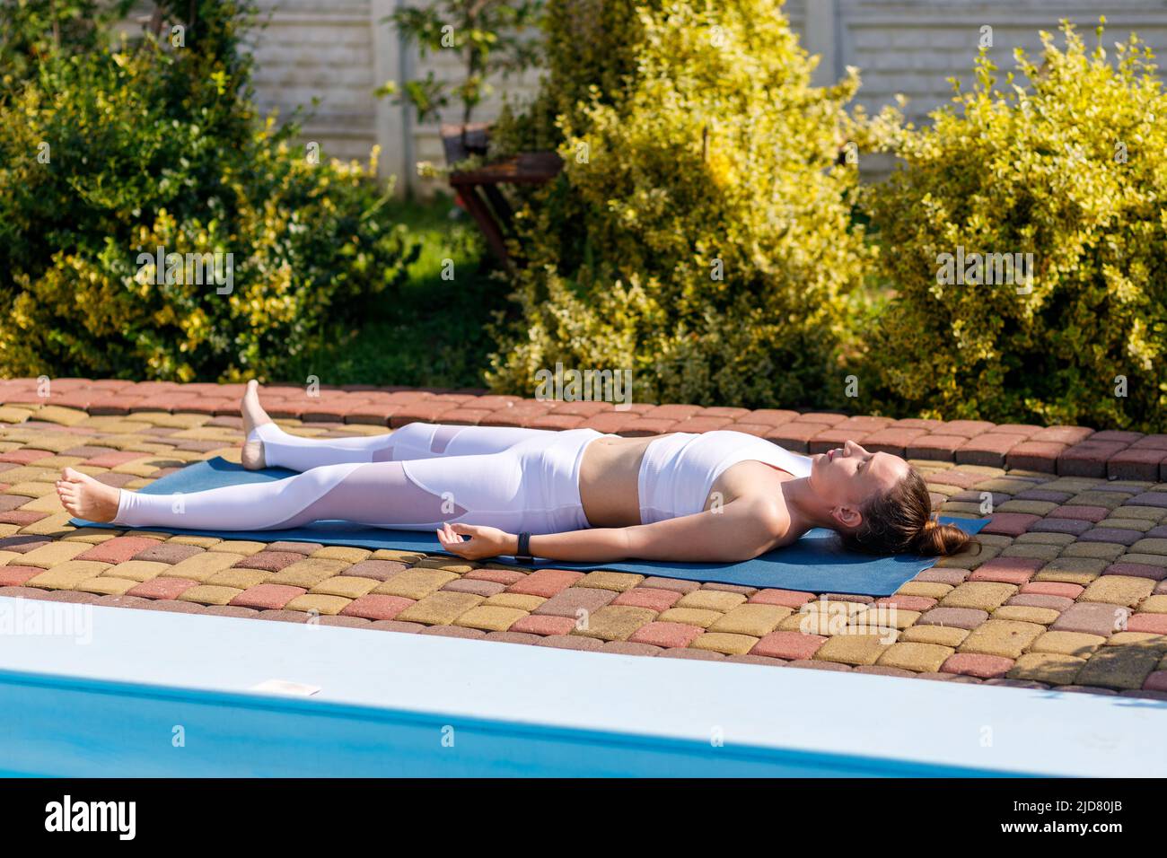 Giovane donna yoga che si rilassa e medita in shavasana al mattino Foto Stock