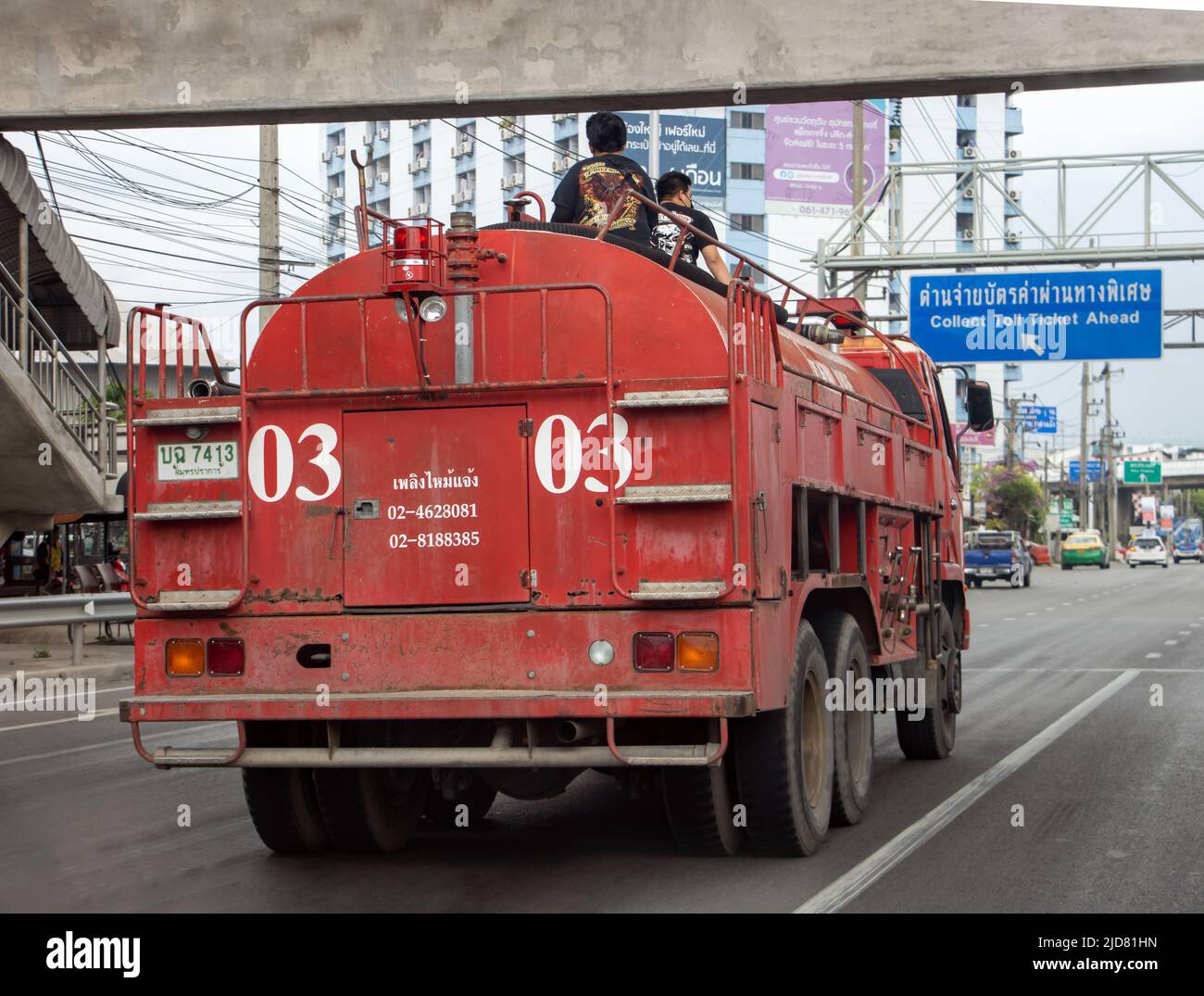 SAMUT PRAKAN, THAILANDIA, 08 2022 MAGGIO, camion del fuoco corre sulla strada con gli uomini sulla cisterna Foto Stock