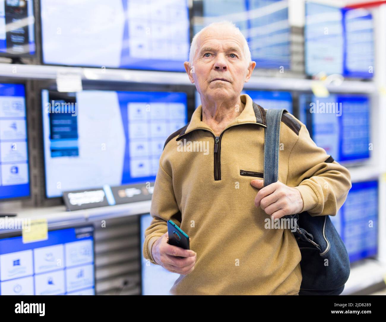 senor uomo pensionato acquistare moderno telelavoro digitale con smart tv in showroom di digital electronic goods store Foto Stock