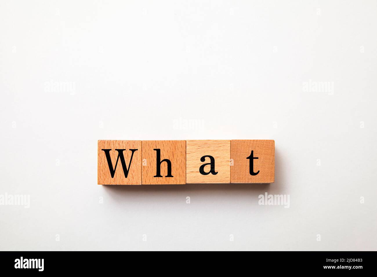 Che carattere. Che cosa. Pronome interrogativo. Scritto su quattro blocchi di legno. Sfondo bianco. Foto Stock